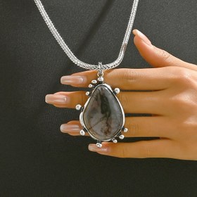 Resim Trendy bir vintage tarzı gümüş rengi herringbone zincir, bir su damlası şeklindeki büyük metal parça ile bir mürekkep çiçeği deseni ve büyük reçine pendent ile eşleştirilmiştir. Sonbahar ve kış kazak kıyafetleri için uygundur ve tüm mevsimlerde giyilebilir. 