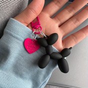 Resim Bir balon köpeği ile fuchsia ve siyah renkli, sevimli ve benzersiz bir çanta aksesuarı olan yaratıcı bir anahtarlık. 