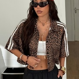 Resim Kadın Y2K Leopar Desenli Kırpma Üstü Düğme Detayları ile - Siyah ve Kahverengi Hayvan Desenli Gömlek, Beyaz Kırpma Atlet, Siyah Pantolon, Kırmızı Başlık, Katmanlı Kolyeler ve Aksesuarlar, Rahat Şık Kıyafet, Rahat Şık Kıyafet | Y2K Modası | Düğme Detaylı Gömlek 