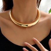 Resim Kadınlar için bir düz, üç boyutlu yuvarlak metal tasarımıyla her gün giyilebilir ve festivaller için uygun bir basit altın tonlu kolye. 