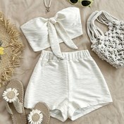 Resim Bir iki parça takımı olan tatil tarzı seksi dokulu askısız crop top, elastik bel şortlarıyla eşleştirilmiştir. 